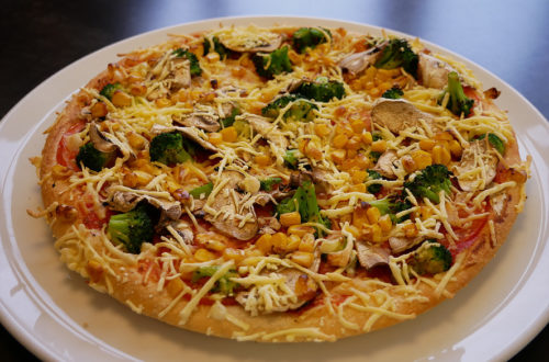 Vegane Pizza von Hallo Pizza! leicht seitlich auf weißem Teller